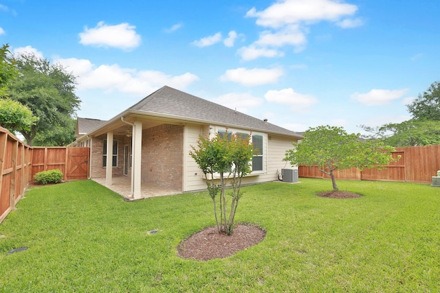 rear view of property with central AC, a lawn, a fenced backyard, a patio, and brick siding