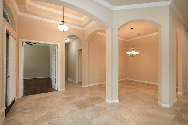 unfurnished dining area with baseboards, arched walkways, a chandelier, crown molding, and stone finish flooring