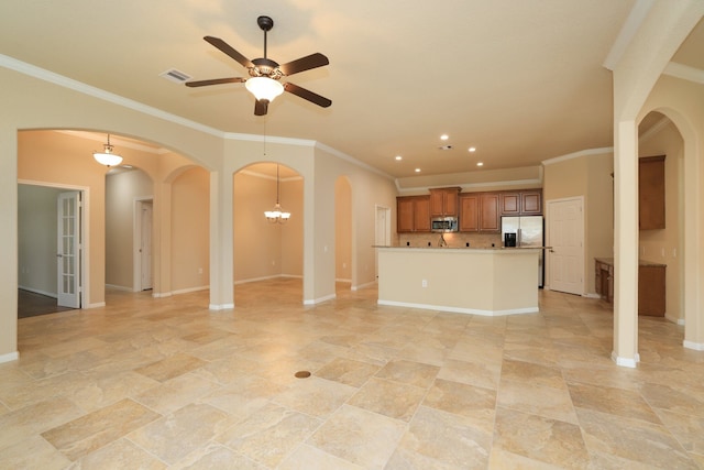 unfurnished living room featuring arched walkways, ceiling fan, ornamental molding, and visible vents