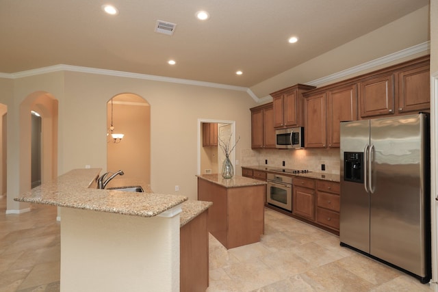 kitchen with a kitchen island with sink, visible vents, appliances with stainless steel finishes, arched walkways, and a sink