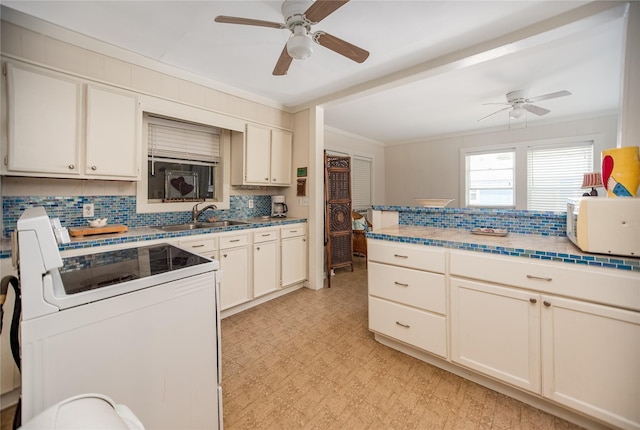 120 W Main St, Port O Connor, TX 77982 - kitchen with range, white microwave, crown molding, a ceiling fan, and tasteful backsplash