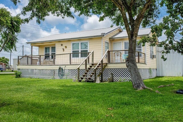 120 W Main St, Port O Connor, TX 77982 - rear view of house with a yard, a wooden deck, and a metal roof