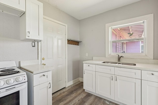kitchen featuring wood finished floors, a sink, light countertops, electric range, and white cabinetry