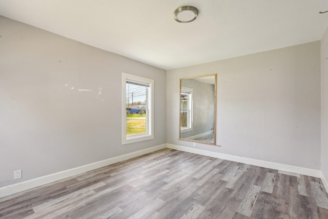 unfurnished room featuring baseboards and wood finished floors