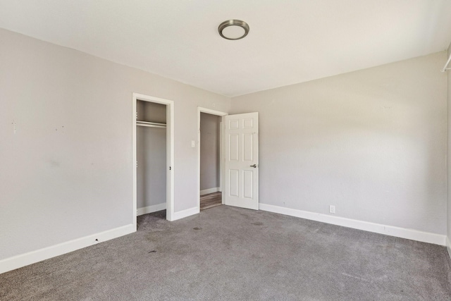 unfurnished bedroom featuring baseboards, carpet, and a closet