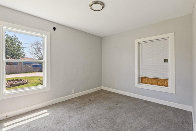 carpeted empty room featuring baseboards