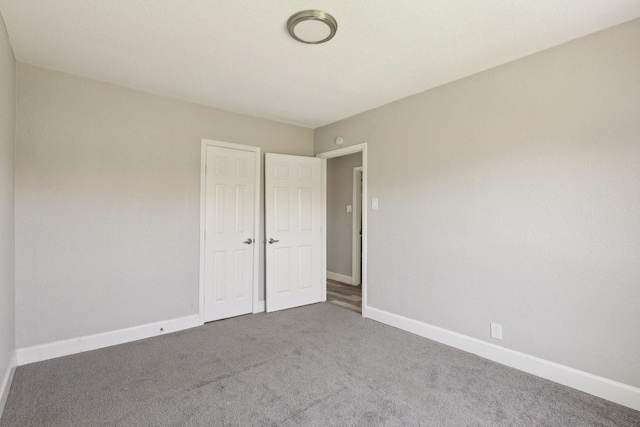 unfurnished bedroom featuring carpet and baseboards