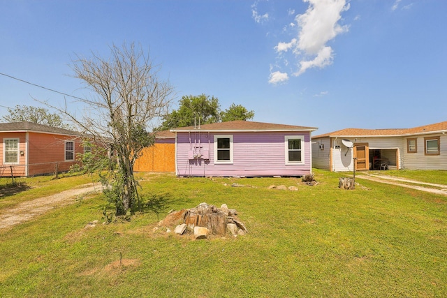 view of front of house featuring a front lawn, driveway, and fence