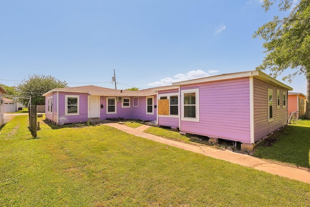 rear view of property featuring a lawn