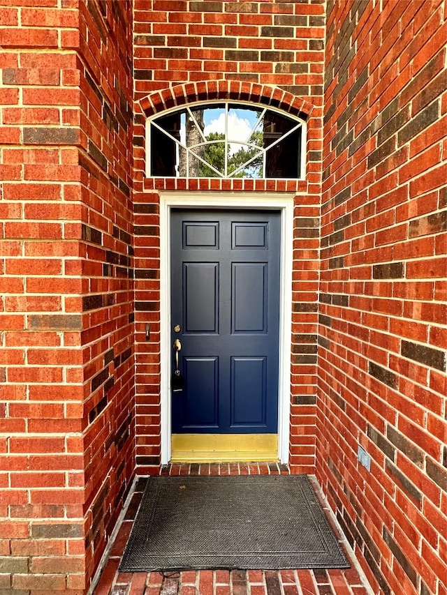 entrance to property featuring brick siding