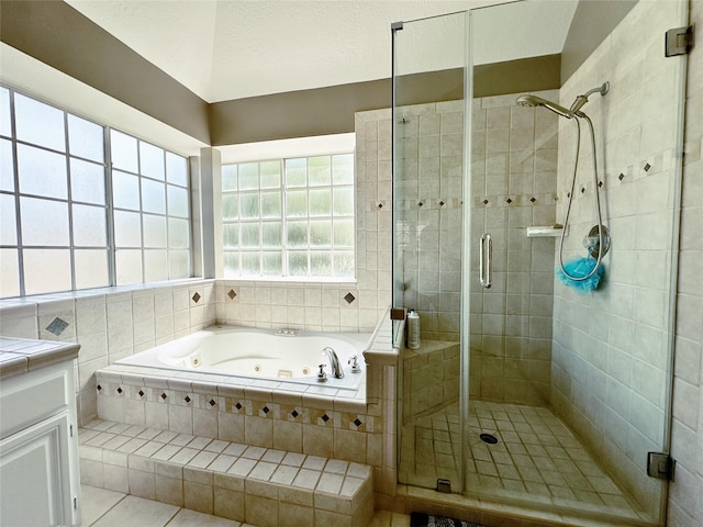 bathroom with a whirlpool tub, a stall shower, tile patterned floors, and vanity