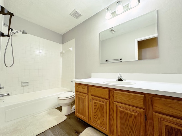 bathroom with toilet, vanity, visible vents, and wood finished floors