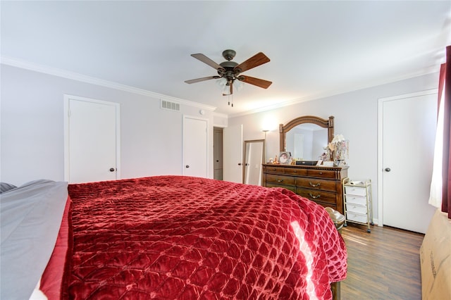 bedroom featuring visible vents, ornamental molding, a ceiling fan, and dark wood-style floors