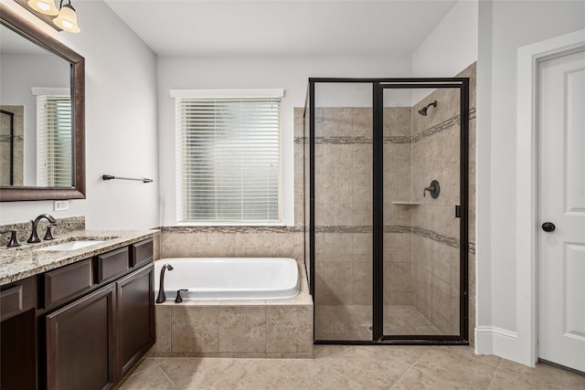 bathroom featuring tile patterned flooring, vanity, a bath, and a stall shower