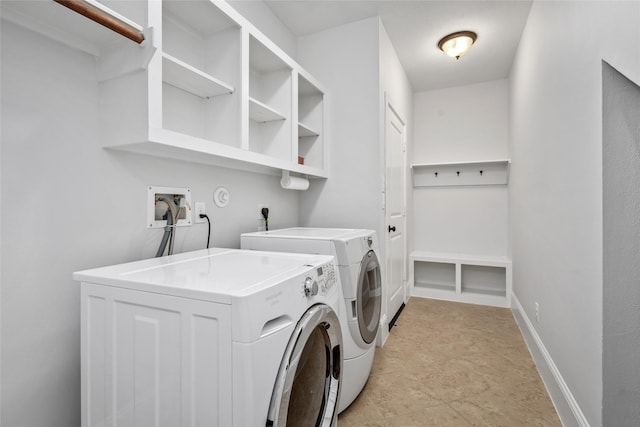 clothes washing area featuring washing machine and dryer, laundry area, and baseboards