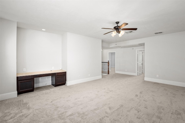 unfurnished living room with visible vents, baseboards, a ceiling fan, and light colored carpet