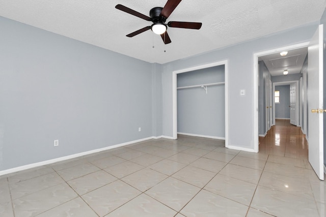 800 Fairway Dr, Richmond, TX 77469 - unfurnished bedroom with a closet, baseboards, light tile patterned floors, a textured ceiling, and attic access
