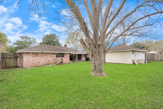 800 Fairway Dr, Richmond, TX 77469 - back of house with roof with shingles, a chimney, brick siding, a yard, and fence