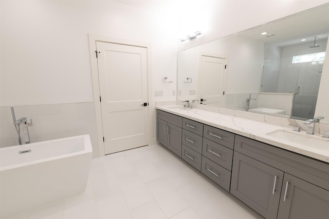 bathroom featuring a sink, double vanity, a shower stall, and a freestanding tub