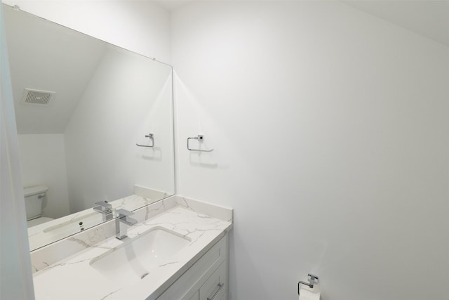 bathroom with visible vents, toilet, and vanity