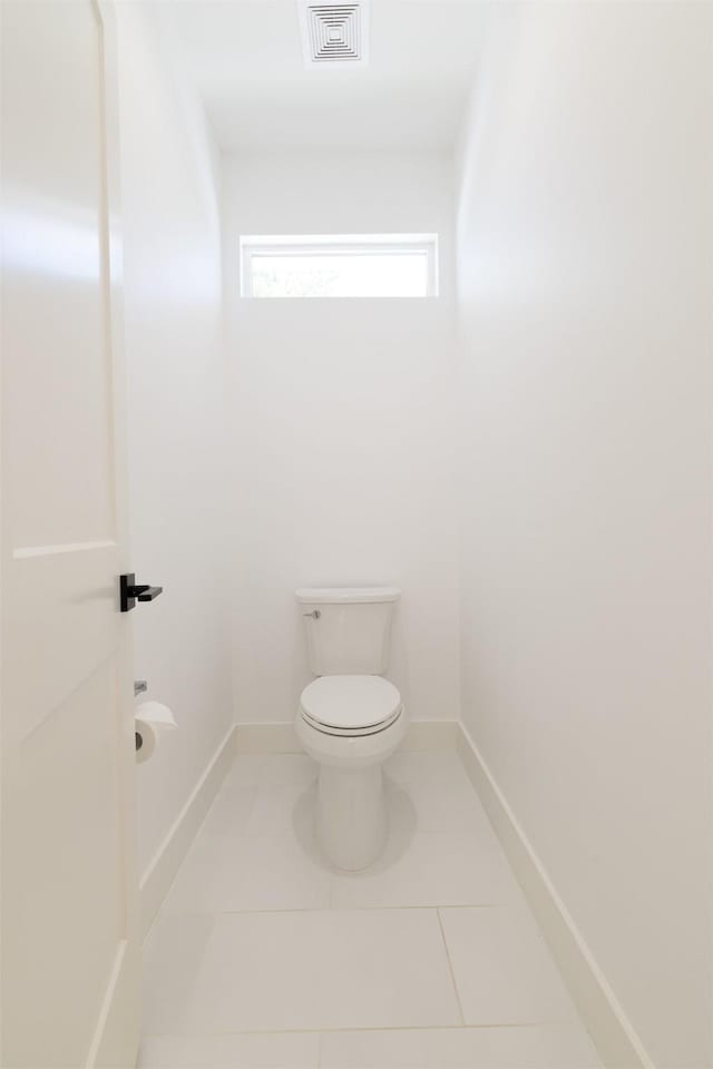 bathroom featuring tile patterned flooring, toilet, baseboards, and visible vents