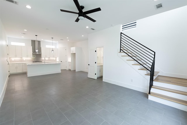 unfurnished living room with visible vents, stairs, baseboards, ceiling fan, and recessed lighting