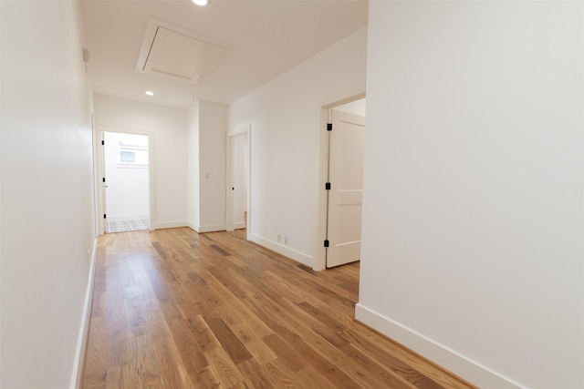 hallway featuring light wood-style floors, baseboards, attic access, and recessed lighting