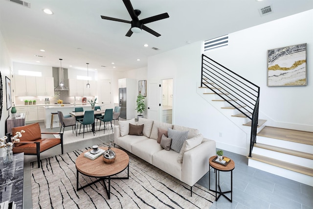 living room featuring recessed lighting, visible vents, ceiling fan, and stairs