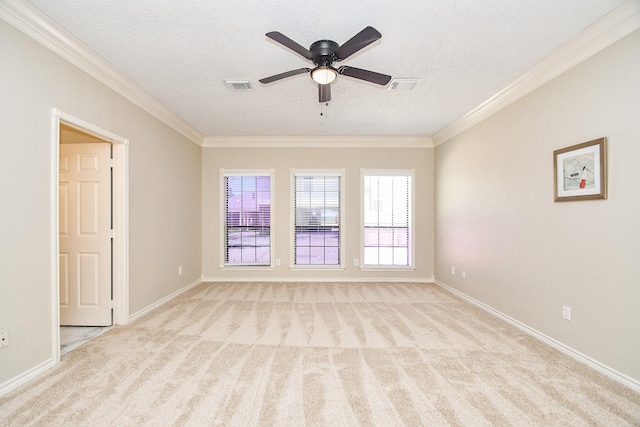 spare room with a textured ceiling, a ceiling fan, ornamental molding, visible vents, and light carpet