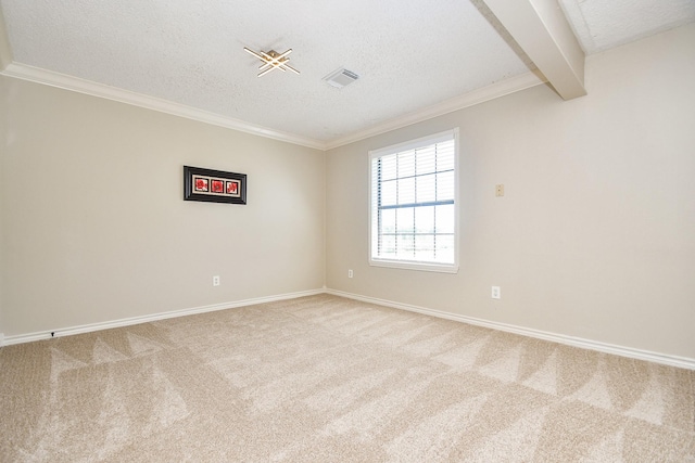 empty room featuring a textured ceiling, ornamental molding, carpet, and visible vents