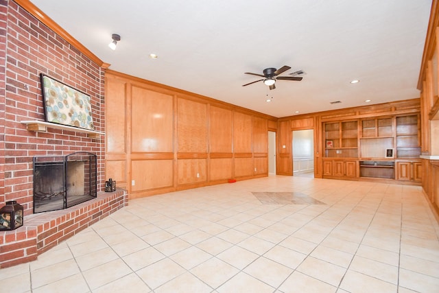 unfurnished living room featuring a decorative wall, a ceiling fan, a brick fireplace, and built in features