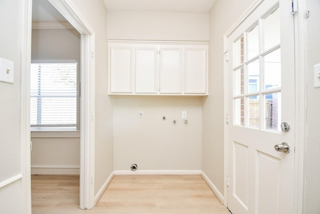 washroom with baseboards, washer hookup, light wood-type flooring, cabinet space, and electric dryer hookup