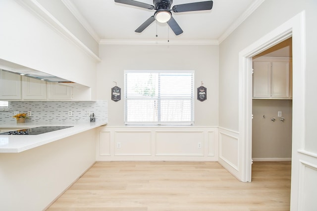 kitchen featuring light wood-style flooring, light countertops, ceiling fan, and decorative backsplash