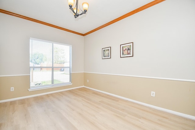 empty room featuring a chandelier, baseboards, crown molding, and wood finished floors