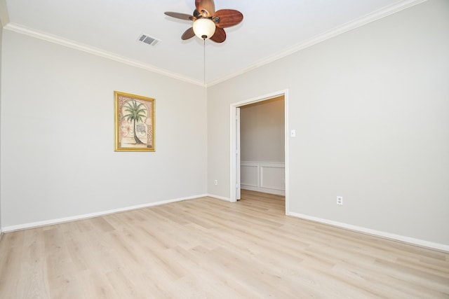 empty room with baseboards, light wood-type flooring, ornamental molding, visible vents, and ceiling fan