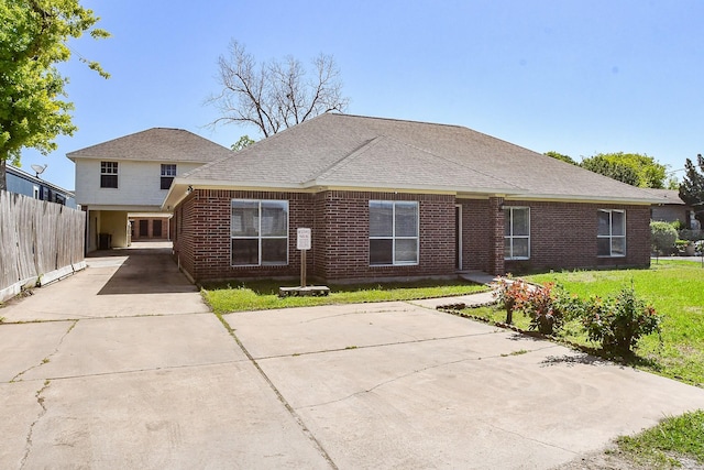 view of front of home featuring brick siding, fence, and concrete driveway
