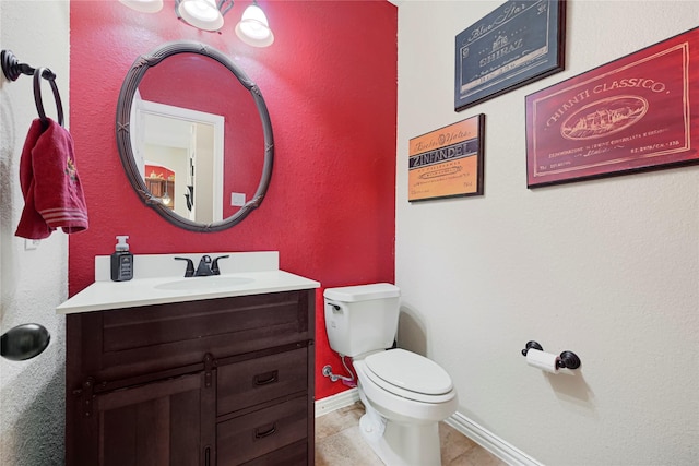 bathroom with baseboards, toilet, tile patterned flooring, and vanity