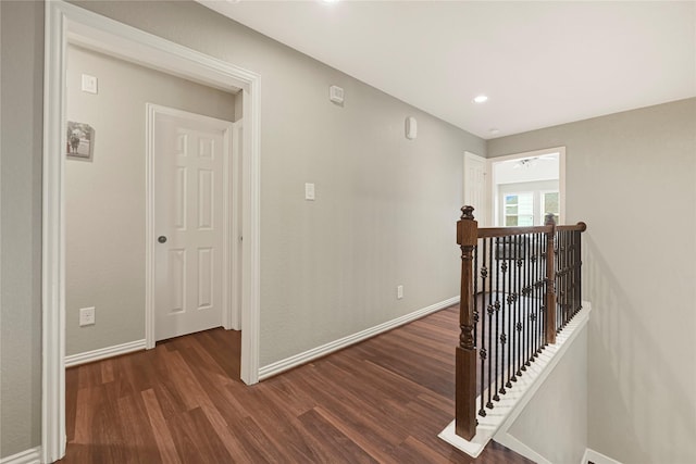 hall featuring baseboards, recessed lighting, an upstairs landing, and dark wood-style flooring