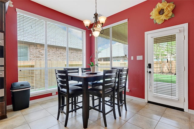 dining space featuring an inviting chandelier, light tile patterned flooring, and plenty of natural light