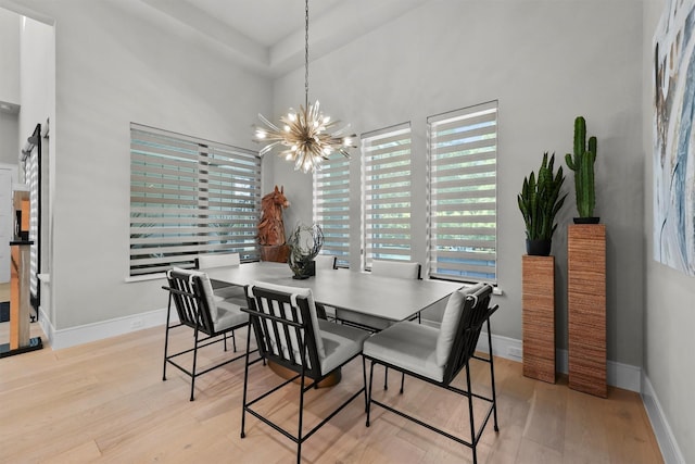 513 Pineal Dr, Montgomery, TX 77316 - dining room featuring light wood finished floors, a chandelier, plenty of natural light, baseboards, and a high ceiling