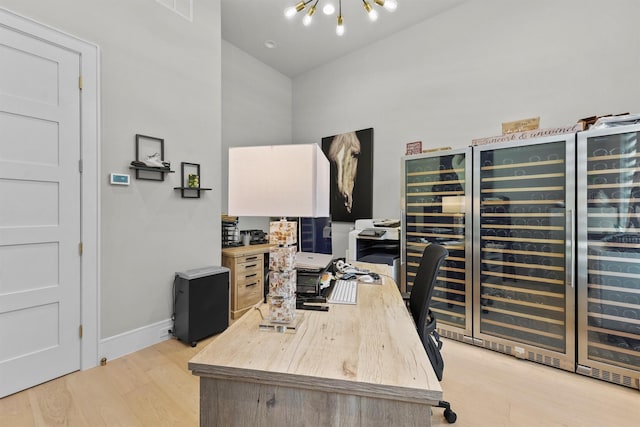 513 Pineal Dr, Montgomery, TX 77316 - office area with beverage cooler, a chandelier, light wood finished floors, baseboards, and a high ceiling