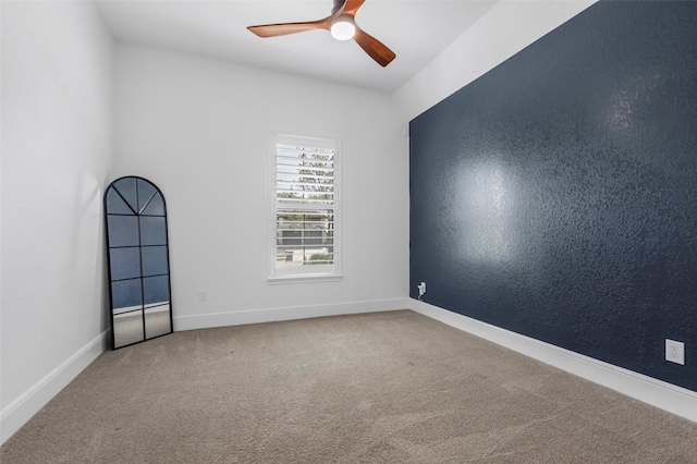 carpeted empty room featuring a ceiling fan and baseboards