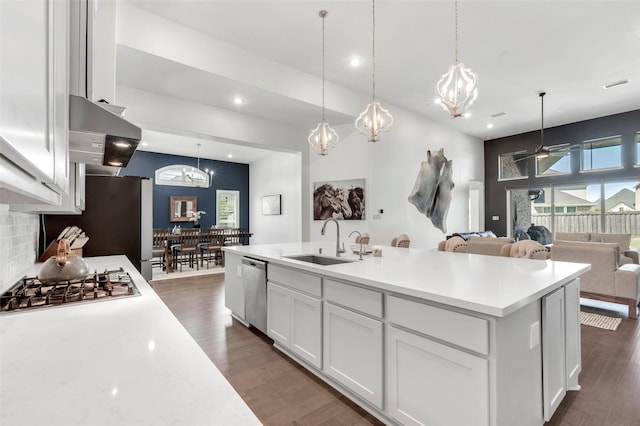 kitchen with ventilation hood, a sink, white cabinetry, light countertops, and appliances with stainless steel finishes