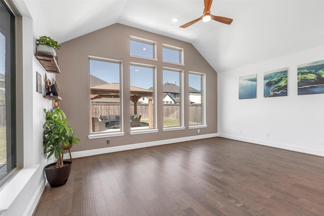 interior space featuring lofted ceiling, a ceiling fan, baseboards, and dark wood-style flooring