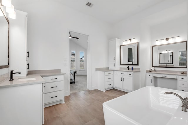 full bathroom with a soaking tub, visible vents, a sink, and two vanities
