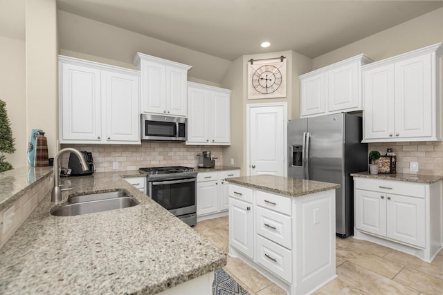 19122 Panther Cave Ct, Cypress, TX 77433 - kitchen with light stone counters, backsplash, white cabinets, stainless steel appliances, and a sink