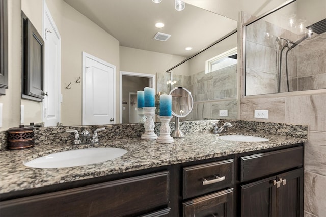 19122 Panther Cave Ct, Cypress, TX 77433 - full bath featuring tiled shower, double vanity, a sink, and visible vents