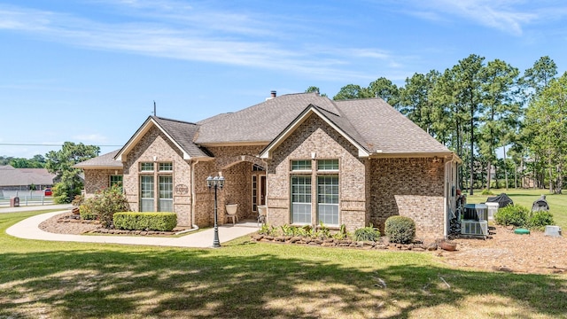 12434 Longmire Way, Conroe, TX 77304 - french country home with brick siding, a front lawn, and roof with shingles