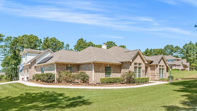 12434 Longmire Way, Conroe, TX 77304 - view of front of home with brick siding, a front yard, a chimney, and a shingled roof