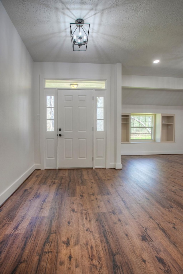 83 Dahlia Rd, Huntsville, TX 77320 - foyer entrance with a chandelier, baseboards, a textured ceiling, and wood finished floors